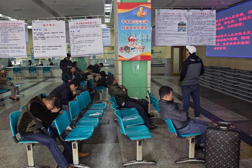 Job seekers wait next to recruitment advertisements at a labour market in Guangzhou, Guangdong province, on Feb 24, 2014.&nbsp;China plans to release figures for unemployment in its big cities in a timely manner, the cabinet said on Wednesday, a chan