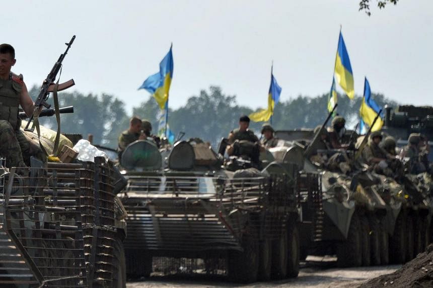 Ukrainian servicemen sitting atop armored personnel carriers (APC) travel near the eastern Ukrainian city of Slavyansk. -- PHOTO: AFP