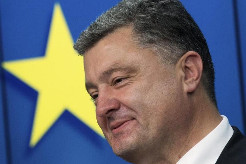 Ukraine's President Petro Poroshenko smiles as he speaks during a news conference at the EU Council in Brussels. -- PHOTO: REUTERS