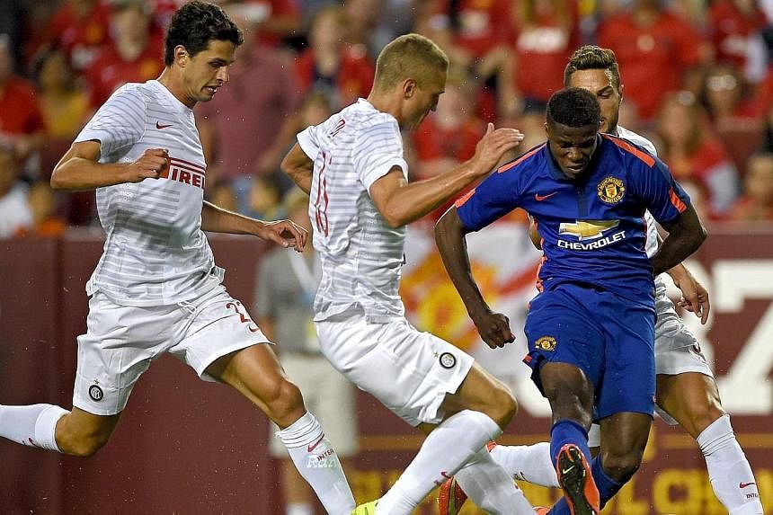 Manchester United's&nbsp;Wilfried Zaha (in blue) shoots as he is defended by Inter Milan players in the second half during their match in the International Champions Cup 2014 at FedExField on July 29, 2014, in Landover, Maryland.&nbsp;-- PHOTO: AFP