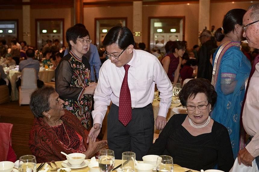 Education minister Heng Swee Keat (centre) greets 100-year-old Mrs Mangalesvary Ambiavagar (left), former principal of Raffles Girls' Primary, Bedok Girls' and Balestier Boys' School, during the Ministry of Education dinner to honour pioneer educator