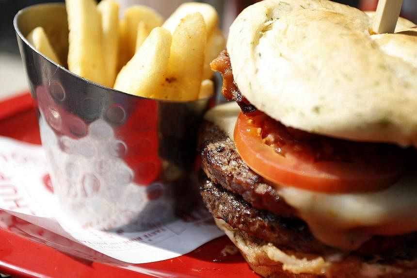 A meal of a "monster-sized" A1 peppercorn burger and bottomless steak fries is seen at a Red Robin restaurant in Foxboro, Massachusetts on July 30, 2014. -- PHOTO: REUTERS