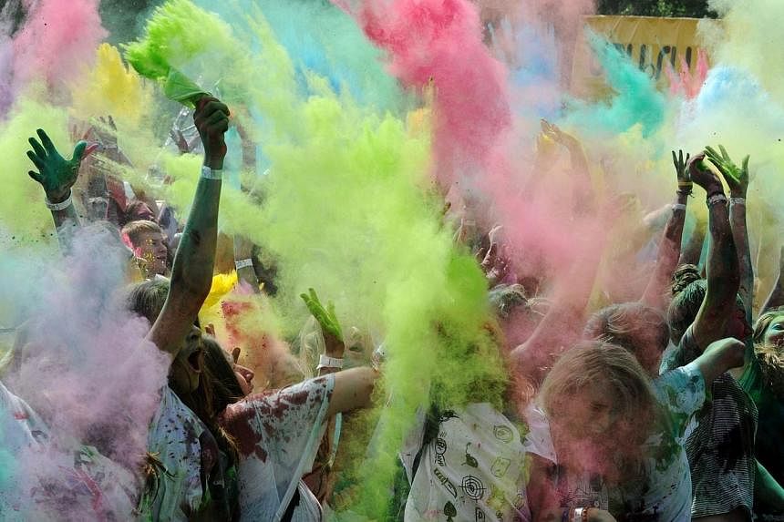 Youngsters throw colored powder at each other during the Festival of Colors in St. Petersburg on July 19, 2014.&nbsp;Russians are happier than ever despite being locked in a dramatic confrontation with the West over Ukraine that has seen their countr