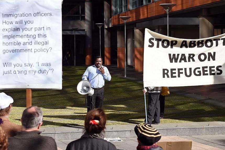A man addresses the crowd at a rally protesting the Australian government's treatment of Sri Lankam asylum-seekers in Sydney on July 7, 2014.&nbsp;Australia's human rights commissioner said on Thursday, July 31, 2014, the government must come clean a
