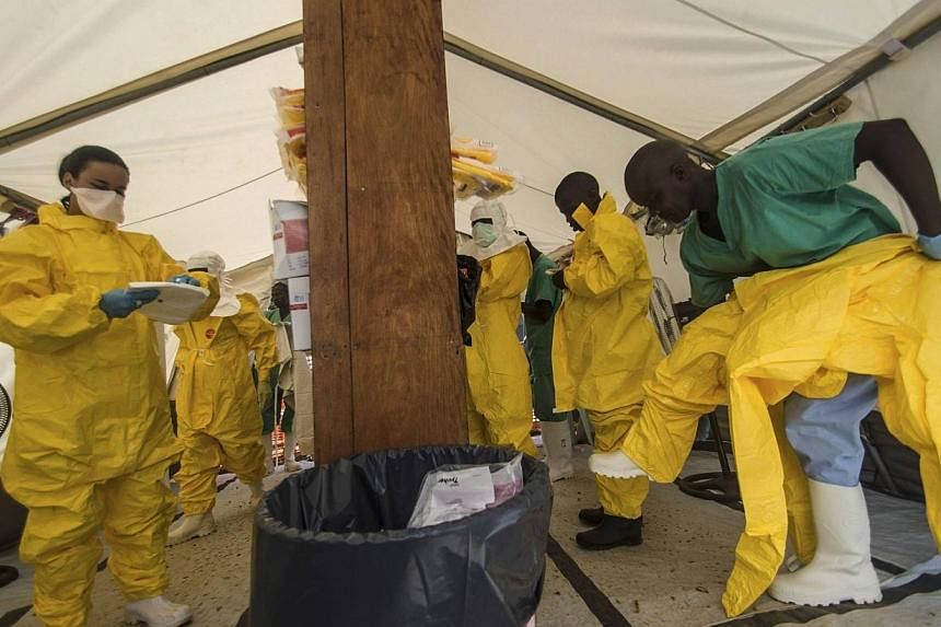 Medical staff working with Medecins sans Frontieres (MSF) put on their protective gear before entering an isolation area at the MSF Ebola treatment centre in Kailahun on July 20, 2014.&nbsp;The World Health Organization (WHO) is not recommending any 