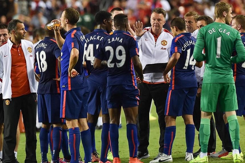 Manchester United's coach Louis van Gaal speaks to his players before a penalty shootout against Inter Milan during a Champions Cup match at FedEx Field in Landover, Maryland on July 29, 2014.&nbsp;Manchester United’s owners on Thursday, July 31, 2