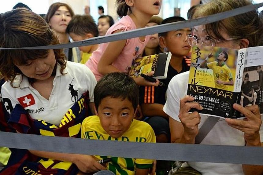 Fans wait for Brazilian football star Neymar to arrive at the Haneda International Airport in Tokyo on July 31, 2014. -- PHOTO: AFP