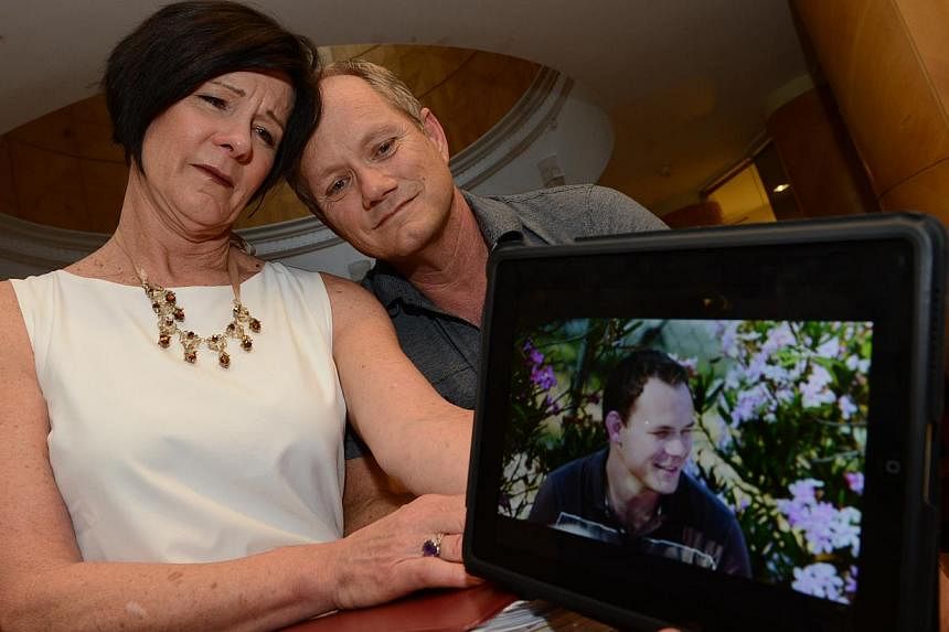 Americans Mary and Rick Todd with a photo of their son Shane, who was found hanged in his Singapore home in June 2012. His parents, who arrived in Singapore in May last year for the coroner's inquiry, believe he was killed.