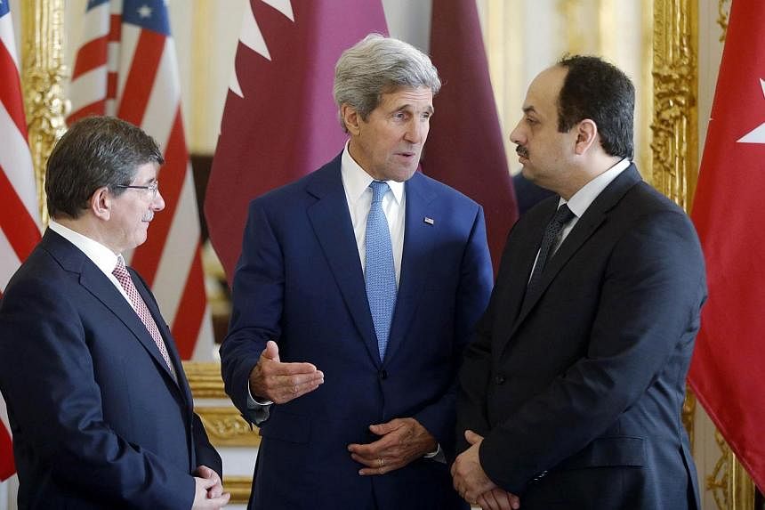 (From left) Turkish Foreign Minister Ahmet Davutoglu, US Secretary of State John Kerry and Qatari Foreign Minister Khaled al-Attiyah speak after their meeting regarding a cease-fire between Hamas and Israel in Gaza, at the foreign ministry in Paris, 