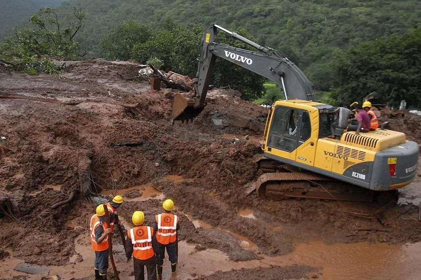 National Disaster Response Force (NDRF) personnel clear the debris from the site of a landslide at Malin village, in the western Indian state of Maharashtra on July 30, 2014.&nbsp;Rescue workers dug through deep mud and debris on Thursday in search o