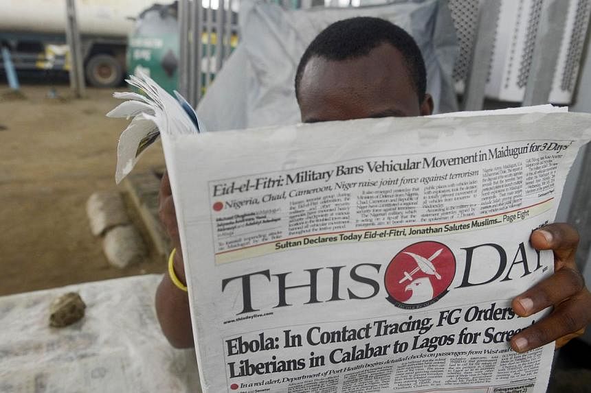 A man reads a newspaper with a headline announcing government efforts to screen for Ebola at a newsstand in Lagos on July 27, 2014.&nbsp;Kenya and Ethiopia, home to some of Africa's largest transport hubs, said on Thursday they had boosted measures t