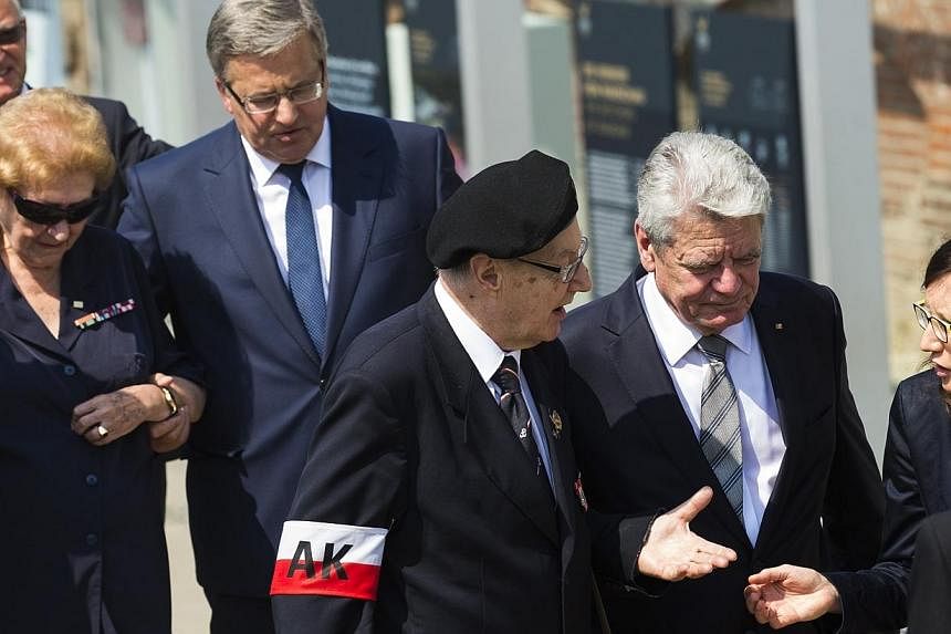 German President Joachim Gauck (2nd right) and his Polish counterpart Bronislaw Komorowski (4th right) talk with veterans of the Warsaw Uprising during the opening July 29, 2014, of a Berlin exhibition about the uprising of the Polish resistance agai