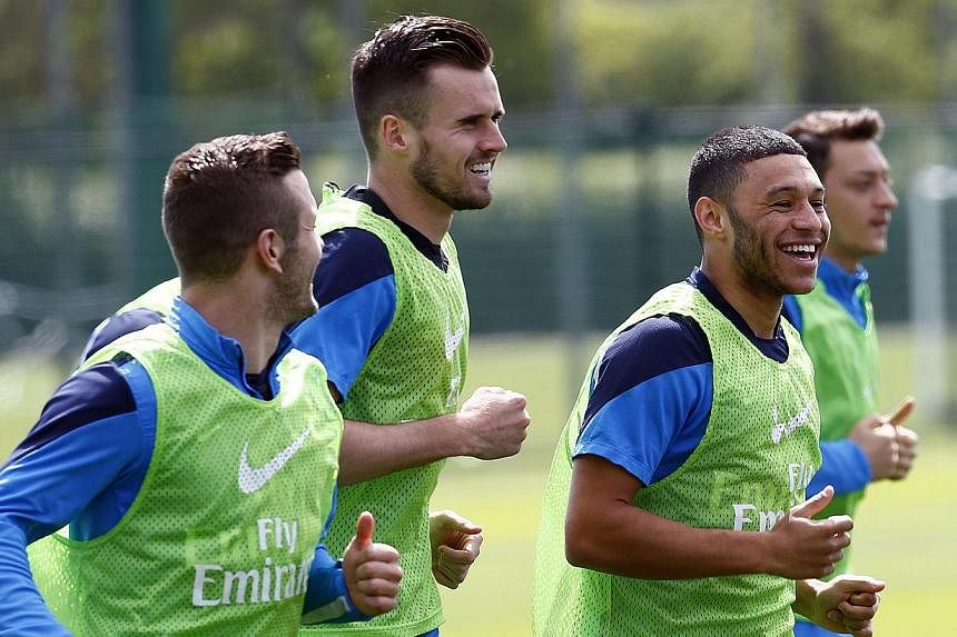 Arsenal's English midfielder Jack Wilshere, (left) English defender Carl Jenkinson, (second left) English forward Alex Oxlade-Chamberlain (second right) and German midfielder Mesut Ozil (right) take part in a training session at their London Colney t