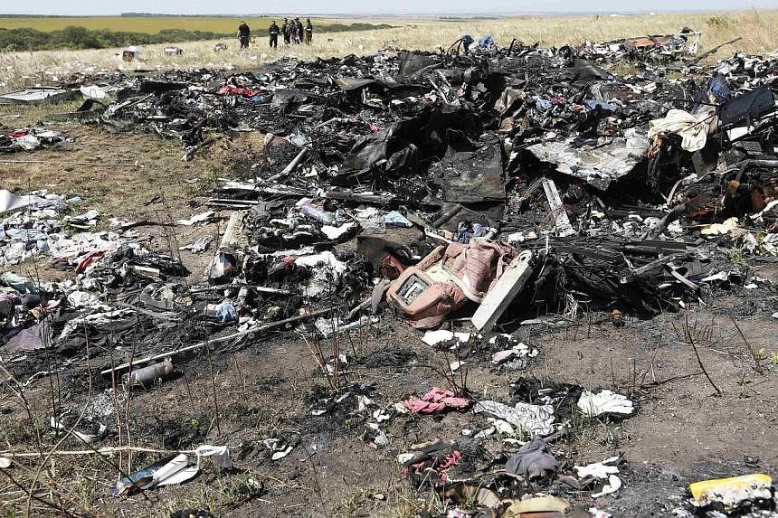 Members of a group of international experts inspect the site where the downed Malaysia Airlines flight MH17 crashed, near the village of Hrabove (Grabovo) in Donetsk region, eastern Ukraine on Aug 1, 2014. -- PHOTO: REUTERS