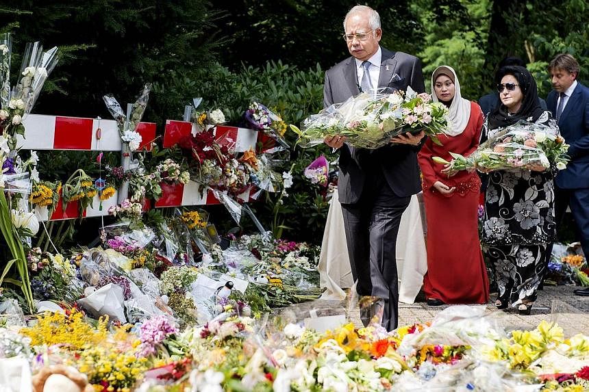 Malaysian Prime Minister Najib Razak and his wife Rosmah Mansor (second from right) lay flowers at the Korporaal van Oudheusdenkazerne in Hilversum, the Netherlands, on July 31, 2014. -- PHOTO: AFP