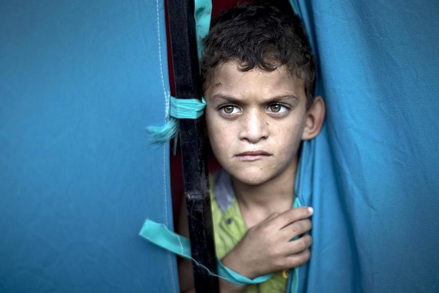 A displaced Palestinian boy looks out from a makeshift tent at the al-Shifa hospital in Gaza City on July 31, 2014. Israel and Hamas have agreed to a 72-hour ceasefire in the Gaza conflict, US Secretary of State John Kerry said early on Friday. -- PH