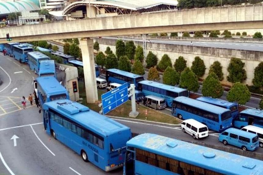The protest by factory bus drivers at the Bangunan Sultan Iskandar Customs, Immigration and Quarantine (CIQ) Complex, Johor Baru on Friday morning may have been instigated by two drivers, several news portals reported.&nbsp;-- PHOTO: THE STAR/ASIA NE