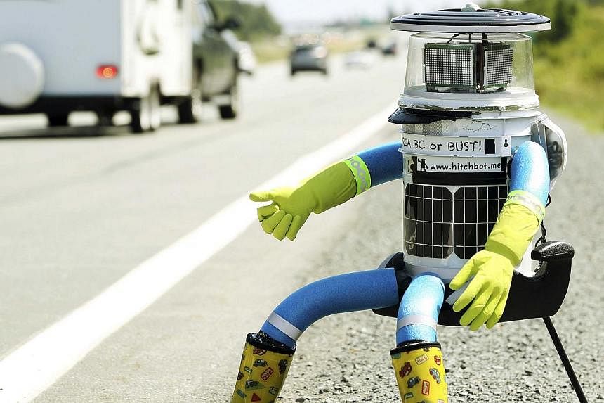 The anthropomorphic robot named hitchBOT sits on the shoulder of Highway 102 to begin its 6000 kilometer cross country journey outside of Halifax, Nova Scotia, July 27, 2014. -- PHOTO: REUTERS&nbsp;