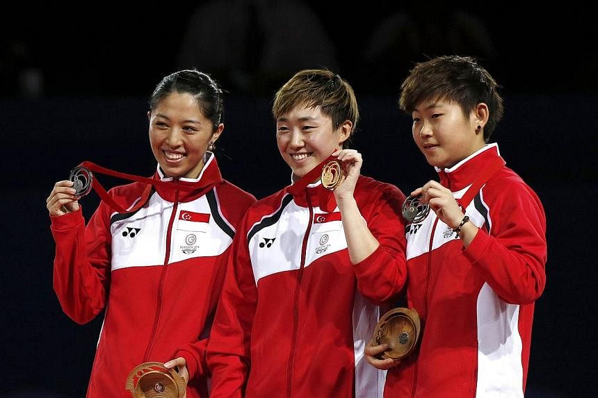 Singapore's gold medalist Feng Tianwei (centre), silver medalist Yu Mengyu (left) and bronze medalist Lin Ye (right) pose on the podium after winning the women's singles table tennis competition at the 2014 Commonwealth Games in Glasgow, Scotland, on