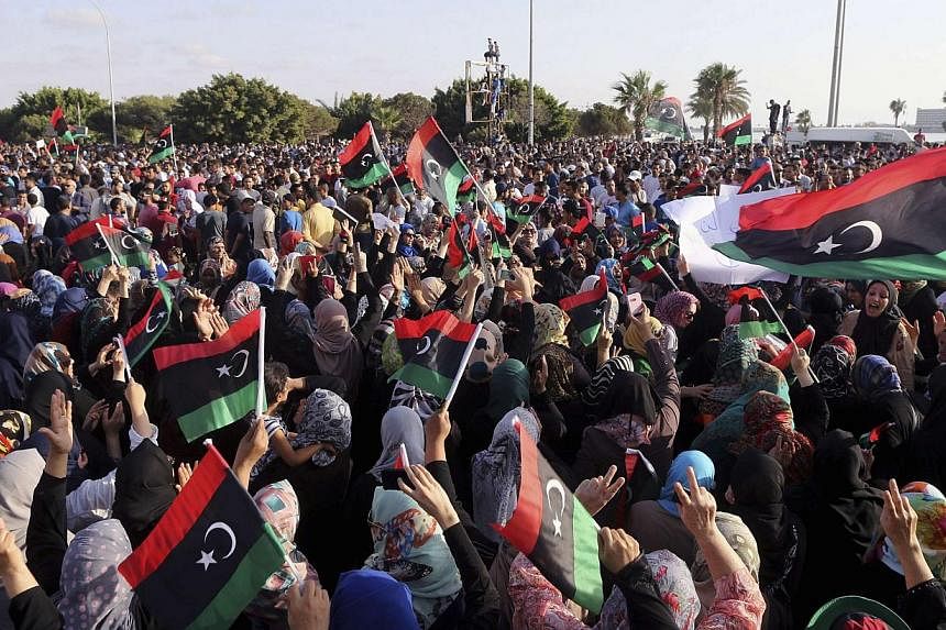 People attend a rally in support of former Libyan army officer Khalifa Haftar, in Benghazi on August 1, 2014. The Philippines urged its thousands of workers in Libya on Saturday to leave the strife-torn nation now while they still can, warning that t