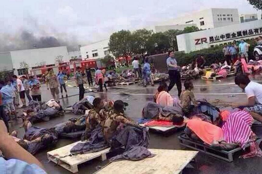 Rescuers help the victims of an explosion at the gate of a factory in Kunshan, Jiangsu province August 2, 2014. The blast killed 65 people, a government broadcaster said, while more than 100 were injured in what appeared to be an industrial accident.