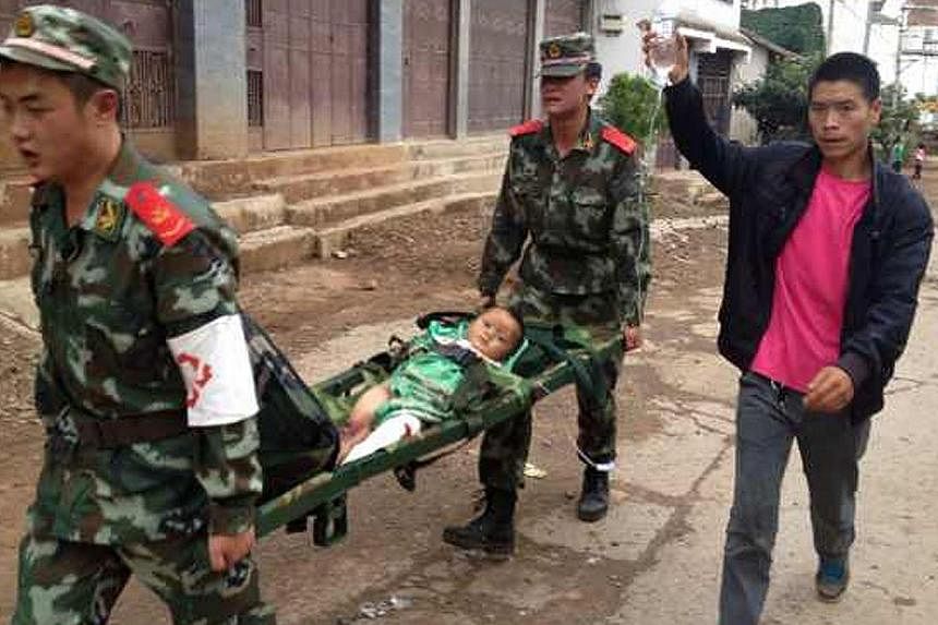 Rescuers carry an injuried child on a stretcher after a 6.3 magnitude earthquake hit the area in Ludian county in Zhaotong, south-west China's Yunnan province on August 3, 2014.&nbsp;A magnitude 6.3 earthquake struck south-western China on Sunday, ki