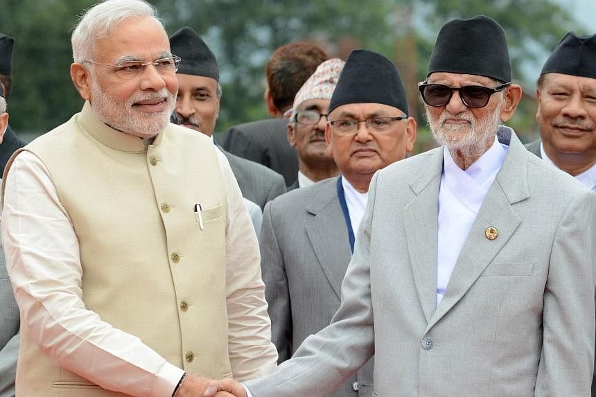 Nepalese Prime Minister Sushil Koirala (right) shakes hands with Indian Prime Minister Narendra Modi on his arrival at Tribhuvan International Airport in Kathmandu on August 3, 2014.&nbsp;Indian Prime Minister Narendra Modi offered Nepal US$1 billion