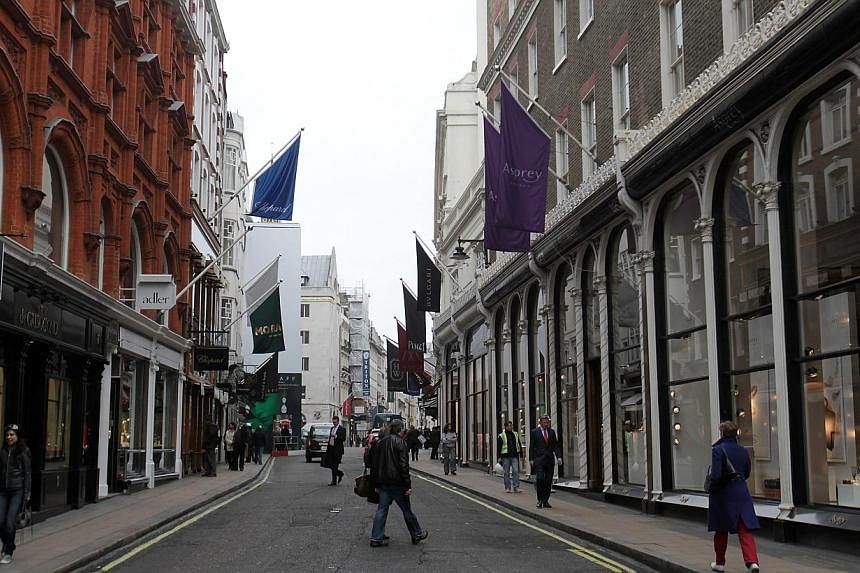Pedestrians walk past luxury stores on New Bond Street in London, UK on Wednesday, on Feb 29, 2012. -- PHOTO: BLOOMBERG