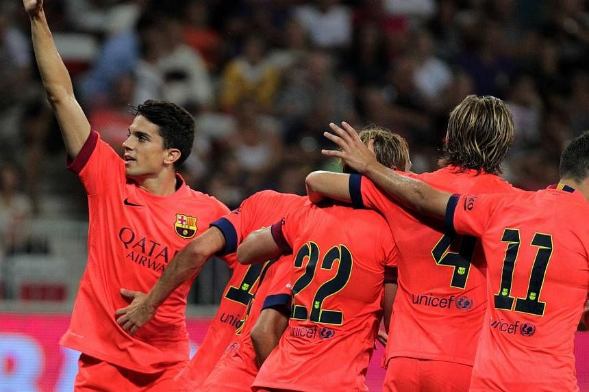 Barcelona's Marc Bartra Aragall (L) and his teammates celebrate after scoring a penalty during a friendly football match Nice (OGCN) vs Barcelona (FCB) on August 2, 2014 at the Allianz Riviera stadium, in Nice, southeastern France. -- PHOTO: AFP