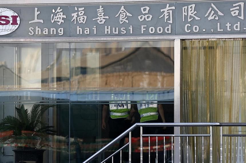 Security guards stand inside the Husi Food factory in Shanghai on July 23, 2014.&nbsp;The police in China have detained six executives of a meat supply company at the centre of the latest food safety scare to hit the country, state media reported on 