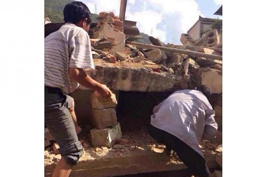Residents look for survivors in the rubble of a collapsed house after a 6.1 magnitude earthquake hit the area in Ludian county in Zhaotong, southwest China's Yunnan province on Aug 3, 2014.&nbsp;A magnitude-6.3 earthquake struck south-western China o