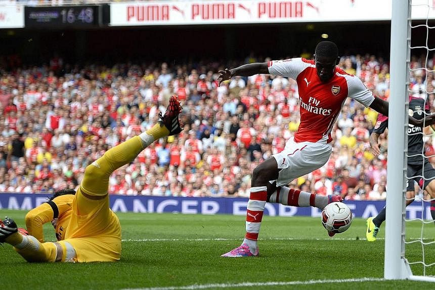 Arsenal's Yaya Sanogo (right) scores past Benfica's goalkeeper Moraes Artur during their Emirates Cup soccer match at the Emirates stadium in London on Aug 2, 2014. -- PHOTO: REUTERS