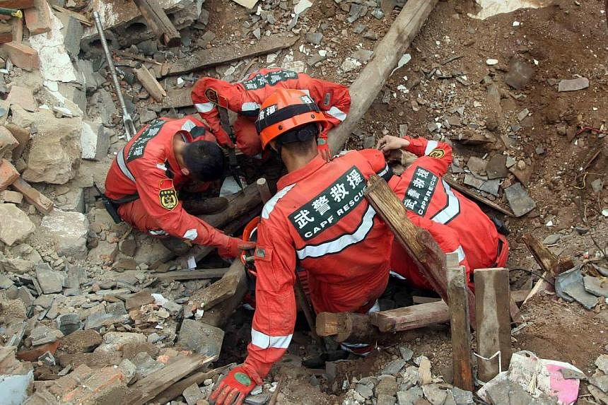 Rescuers search for survivors in debris after an earthquake hit Ludian county in Zhaotong, southwest China's Yunnan province on August 4, 2014.&nbsp;A couple from Ludian county here reportedly dug their four children out of the rubble after their hom