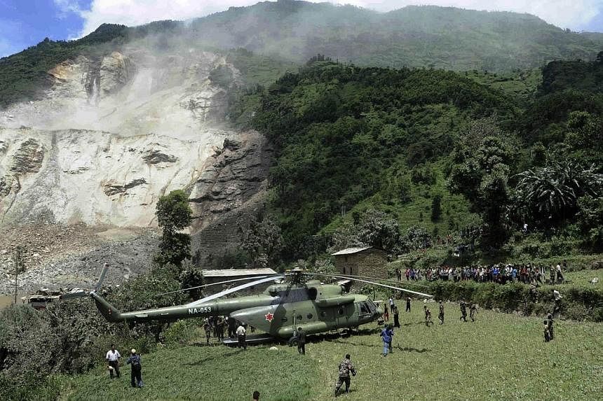 In this photograph released by the Nepalese Army on Aug 2, 2014, a Nepalese Army helicopter lands at the scene of a landslide near the Sunkoshi River north-east of Kathmandu. More than 500 foreign tourists and their guides have been rescued after a d