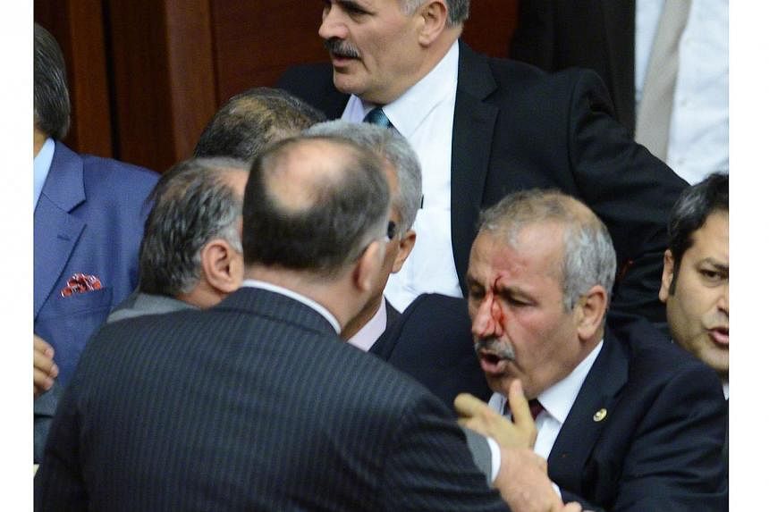 Opposition party&nbsp;MHP deputy Ali Uzunirmak&nbsp;(right) reacts during a fight with a deputy of the AKP ruling party at the parliament in Ankara, on August 4, 2014.&nbsp;