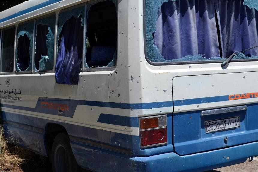 A handout picture released by the official Syrian Arab News Agency (SANA) on August 3, 2014, shows a damaged bus in Damascus' Mazeh district following a reported rebel mortar attack on the southern districts of the capital. At least 44 people were ki