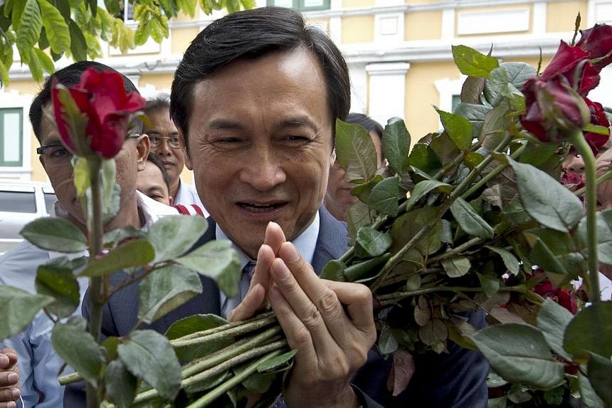 Chaturon Chaisang, who was education minister in the government ousted by the military, gestures after receiving roses from supporters as he arrives at a military court in Bangkok on Monday, Aug 4, 2014.&nbsp;Chaturon Chaisang&nbsp;could face up to 1