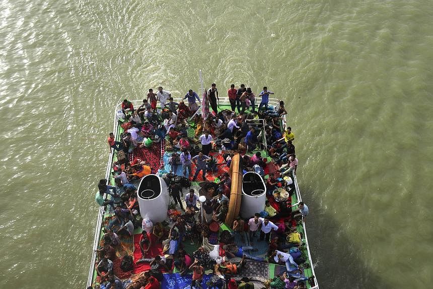 Bangladeshis ride on packed ferries as they rush home to be with their families in their respective villages ahead of the Eid al-Fitr festival, near the Sadarghat ferry terminal on the outskirts of Dhaka on July 27, 2014.&nbsp;An overloaded ferry car