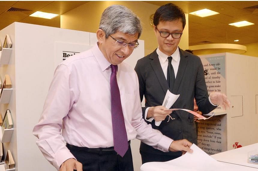 Dr Yaacob Ibrahim (left), Minister for Communications and Information, looking at the resources during the launch of Read! Fest programme on 20 June 2014. -- PHOTO: ST FILE&nbsp;