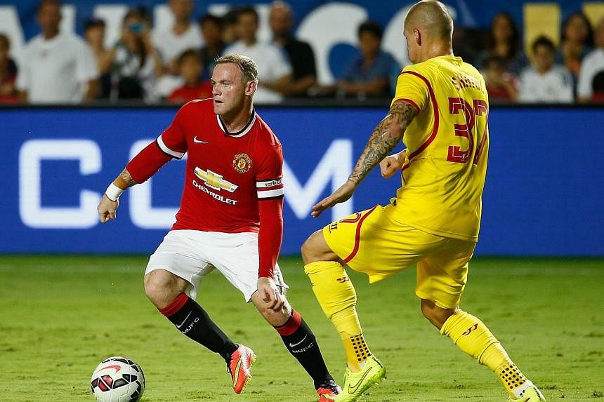 Manchester United's Wayne Rooney (left) is challenged by Martin Skrtel of Liverpool during the International Champions Cup 2014 final at Sun Life Stadium on Aug 4, 2014, in Miami Gardens, Florida. -- PHOTO: AFP