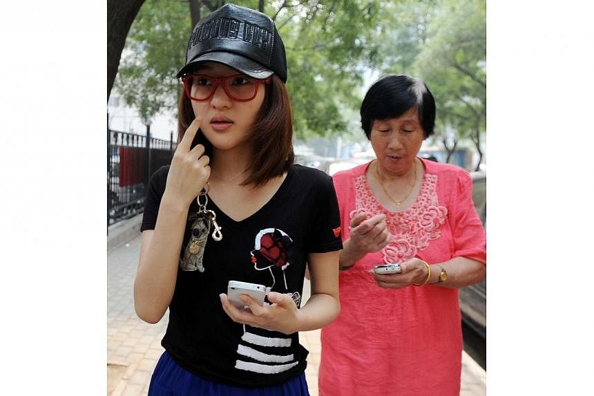 This picture taken on August 21, 2011 shows Guo Meimei (centre) walking out from a police station with her grandmother after reporting her and her family members being harrassed by strangers in Beijing.&nbsp;Chinese Internet users rose up in anger Tu