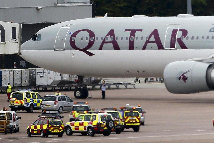 A Qatar Airways aircraft is seen surrounded by emergency vehicles at Manchester airport in Manchester, northern England August 5, 2014.&nbsp;British fighter jets escorted a passenger plane into Manchester airport on Tuesday after the pilot reported t
