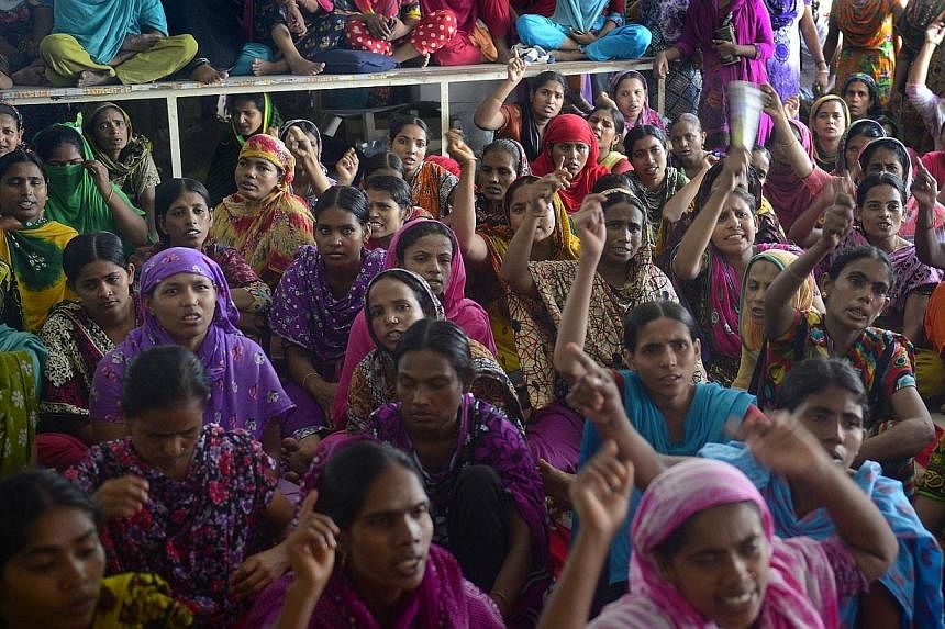 Bangladesh garment workers from the Tuba Group shout slogans as they protest unpaid salaries, in Dhaka on Aug 2, 2014. -- PHOTO: AFP