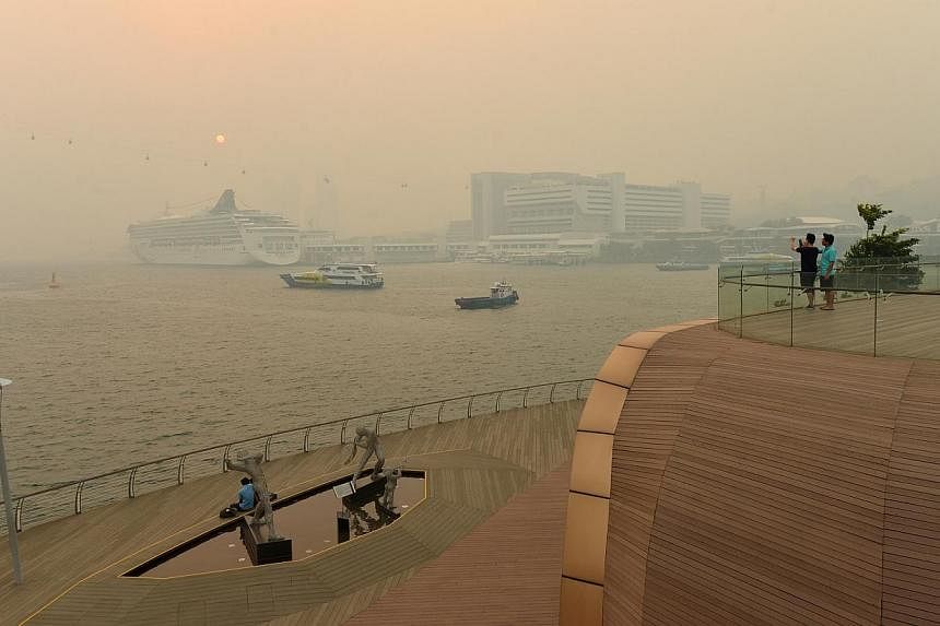 People taking in the view along the Sentosa bridge at 6pm on June 19, 2013, unfazed by the haze.&nbsp;The penalties in a new law to combat haze could rise if future reviews find them insufficient, said Environment and Water Resources Minister Vivian 