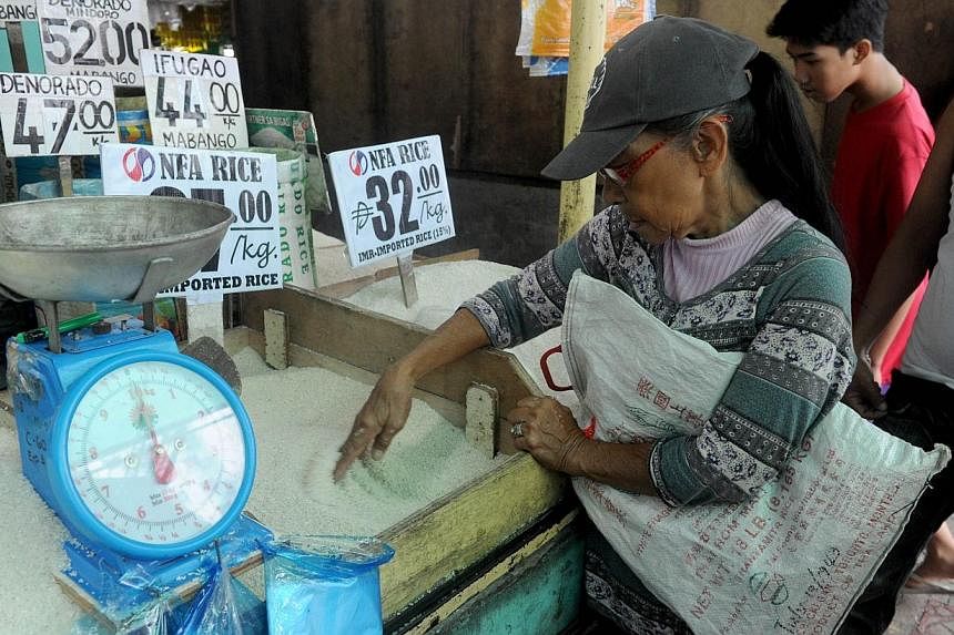 An elderly women buys rice at a market in Manila on Tuesday, Aug 5, 2014.&nbsp;Philippine inflation shot up to a nearly three-year high of 4.9 per cent in July, as millions of poor Filipinos endured steep price rises for essential foods, official dat