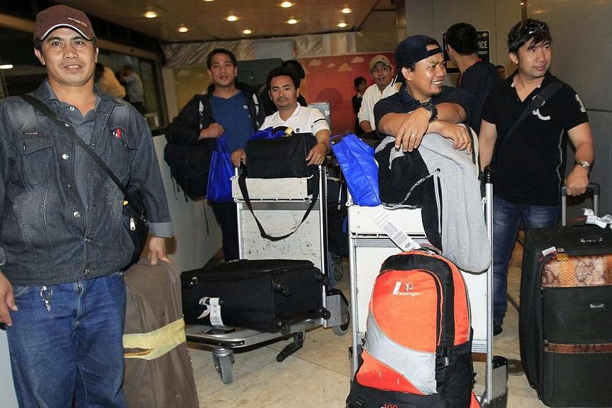 Filipino workers arriving at Ninoy Aquino International Airport from conflict-torn Libya wait with their belongings at the airport in Manila August 4, 2014. The Philippine government was encouraging all workers still in Libya to flee the country whil