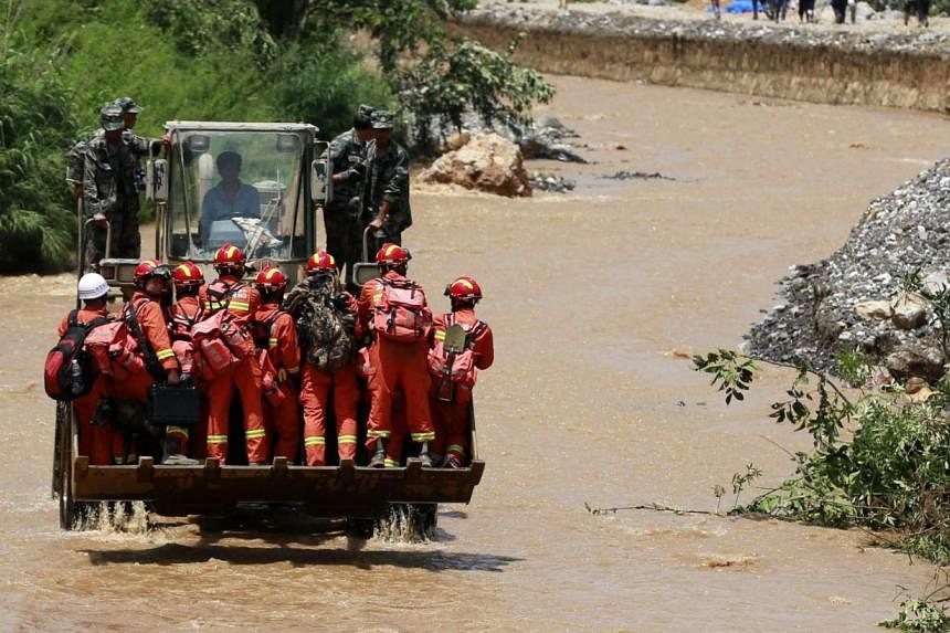 Rescue workers are transported into an earthquake zone on a front loader in Zhaotong, Yunnan province, on Tuesday, Aug 5, 2014.&nbsp;An earthquake in China on the weekend triggered landslides that have blocked rivers and created rapidly growing bodie