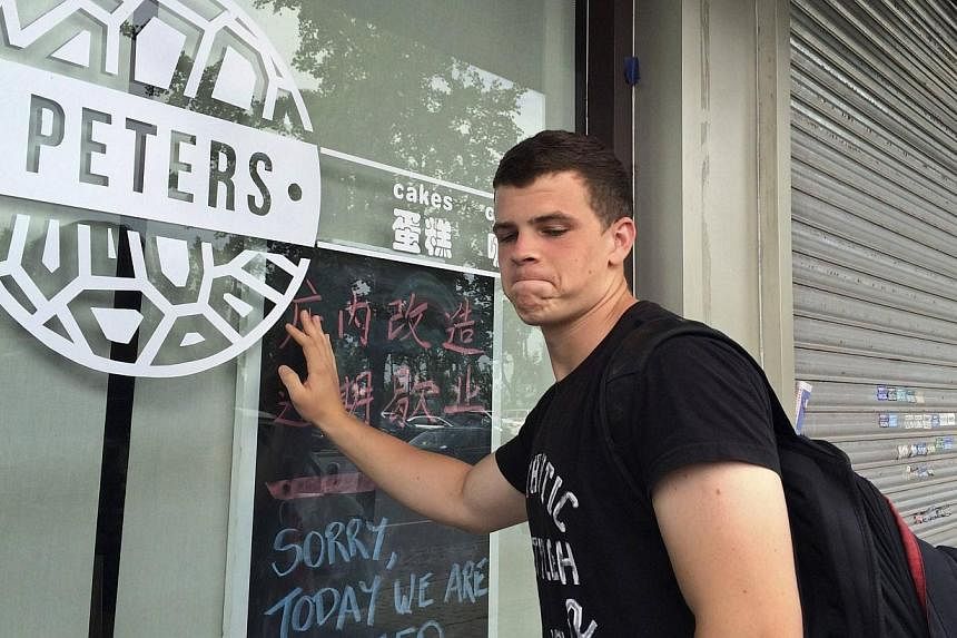 Peter Garratt, one of the sons of Canadian couple Kevin and Julia Dawn Garratt who are being investigated in China for threatening national security, stands outside his parents' coffee shop as he talks to Reuters journalists in Dandong, Liaoning prov