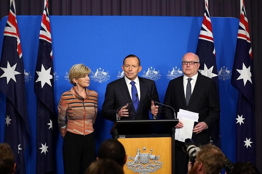 This picture released by the Australia Prime Minister Office on Aug 5, 2014 shows Prime Minister Tony Abbott (centre) speaks at a joint press conference with foreign minister Julie Bishop and Attorney General George Brandis (right) in Canberra. -- PH
