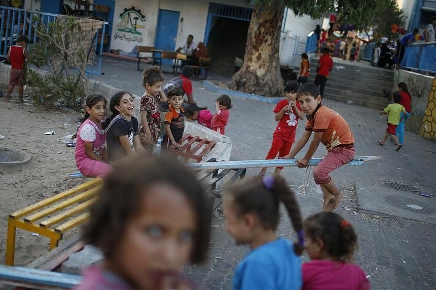 Palestinian children, who fled their houses during Israeli offensive, play at a United Nations-run school sheltering displaced Palestinians, in Gaza City on Aug 2, 2014. -- PHOTO: REUTERS